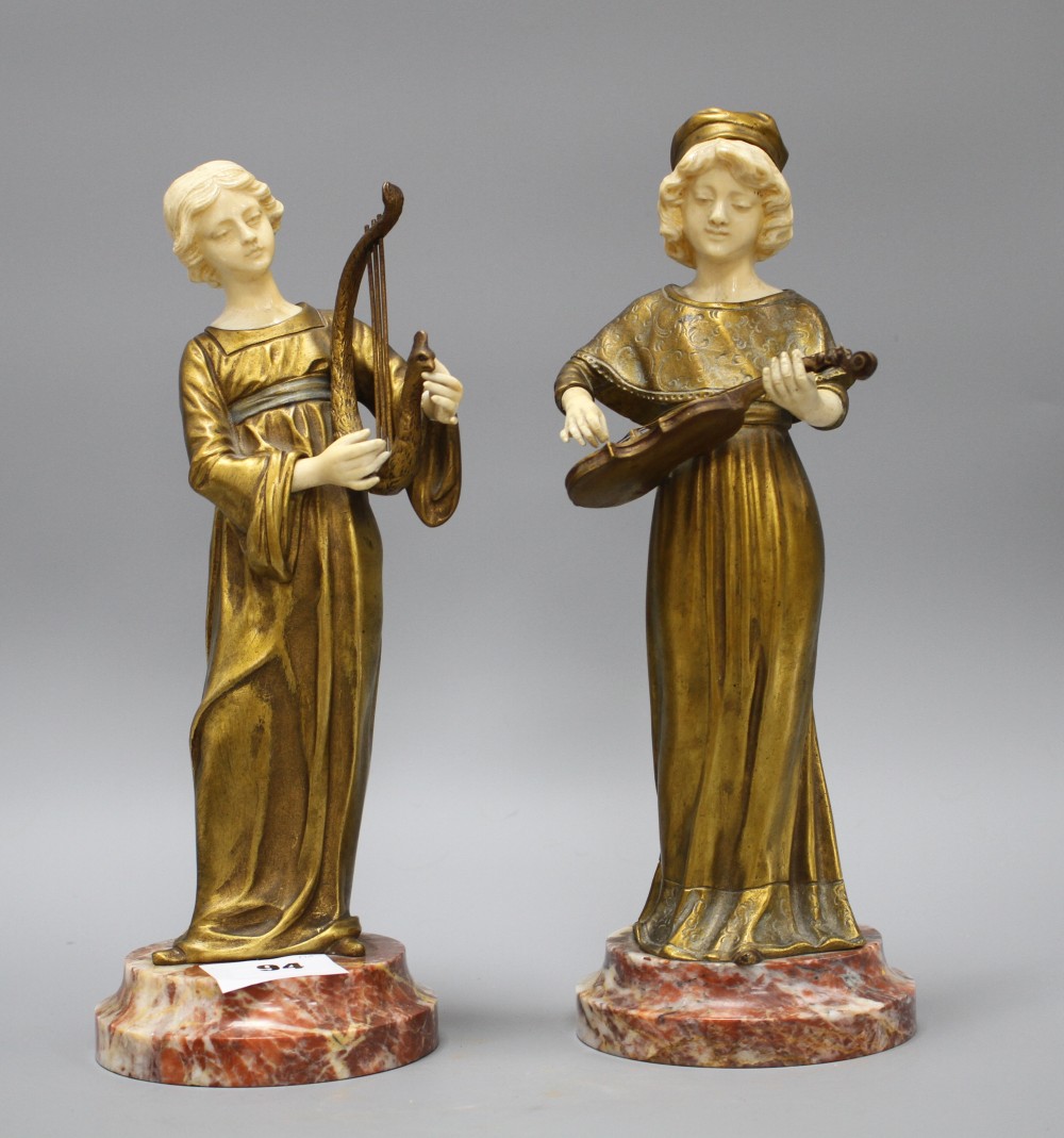 A pair of Alphonse Gori ivory and ormolu figures of medieval musicians, girl playing an Irish harp, the other plucking a violin, on mar